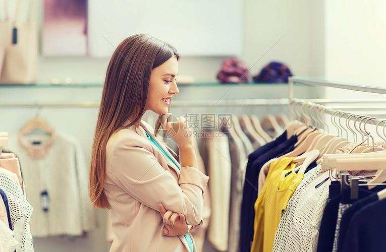服装店快乐的轻女人商场里选择衣服高清图片下载-正版图片300414870